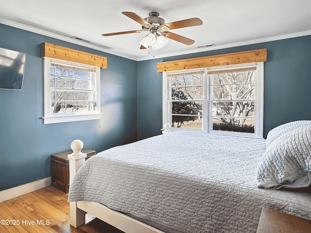 bedroom featuring ceiling fan, ornamental molding, and hardwood / wood-style flooring