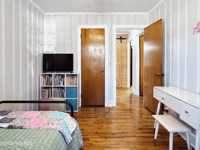 bedroom featuring crown molding and light hardwood / wood-style floors