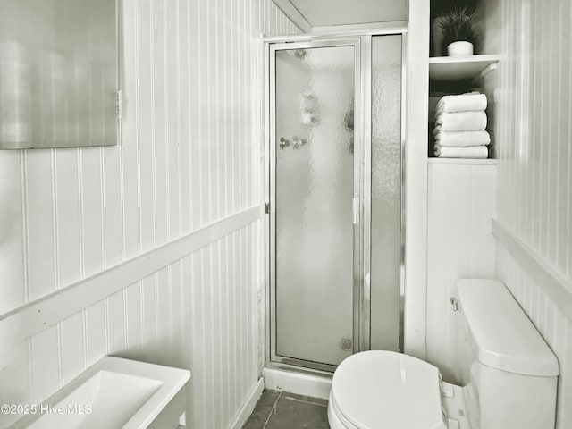 bathroom with a shower with shower door, tile patterned flooring, and toilet