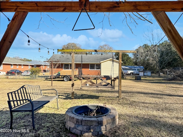 view of yard with an outdoor fire pit and a storage shed