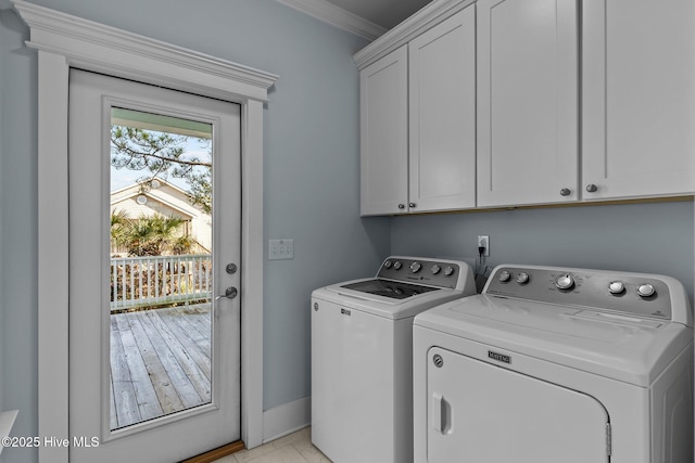 washroom with crown molding, cabinets, and washer and clothes dryer