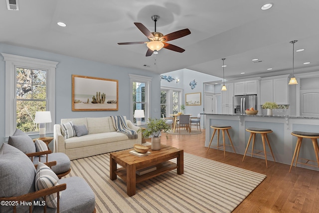 living room featuring light hardwood / wood-style floors and ceiling fan