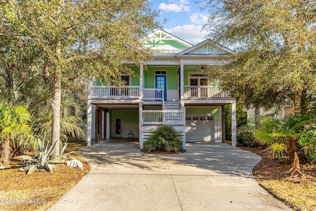 coastal home with a garage, covered porch, and a carport