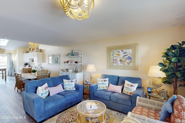 living room with a healthy amount of sunlight, hardwood / wood-style flooring, and a chandelier