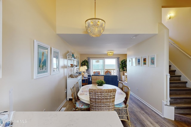 dining space with hardwood / wood-style floors and a chandelier