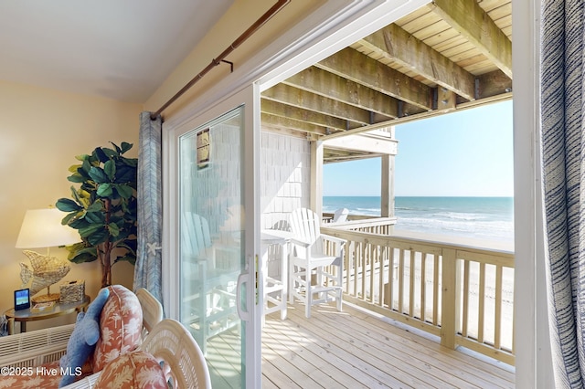 balcony featuring a beach view and a water view