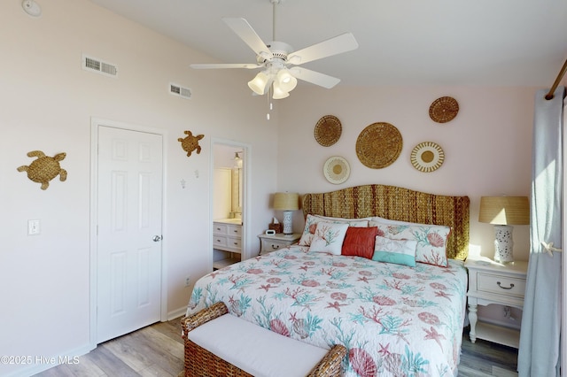 bedroom featuring ceiling fan, ensuite bathroom, and light wood-type flooring