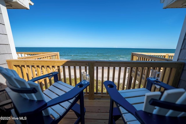 balcony featuring a beach view and a water view