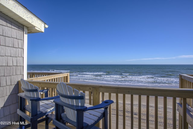 balcony featuring a view of the beach and a water view