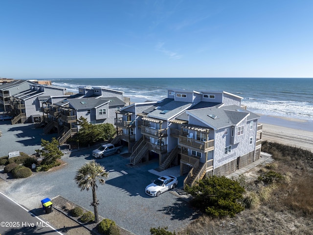 bird's eye view featuring a water view and a beach view