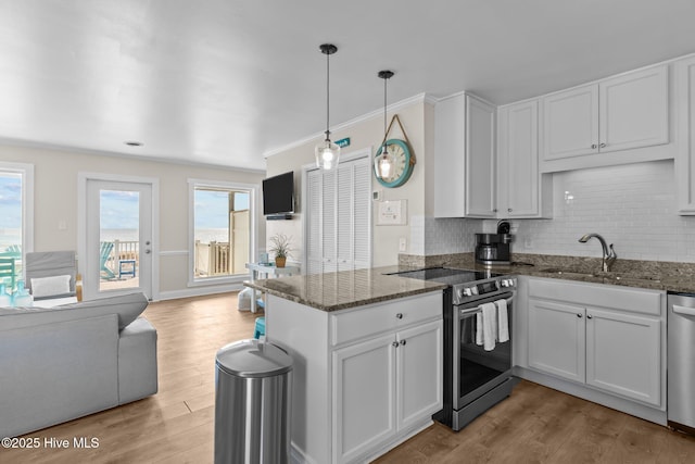 kitchen with sink, white cabinetry, hanging light fixtures, appliances with stainless steel finishes, and kitchen peninsula