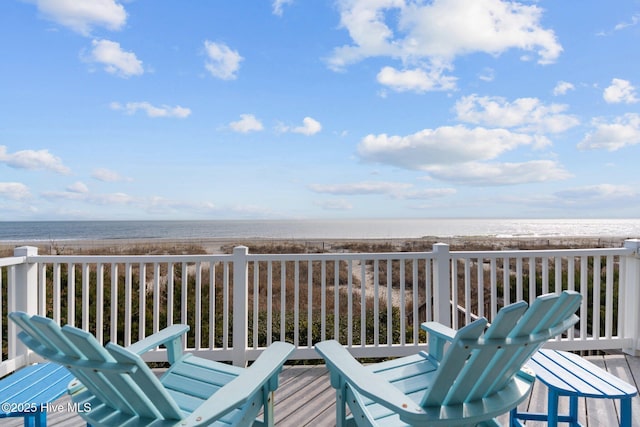 wooden terrace with a view of the beach and a water view