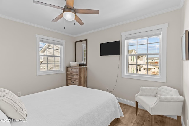 bedroom featuring ornamental molding, light hardwood / wood-style floors, and multiple windows