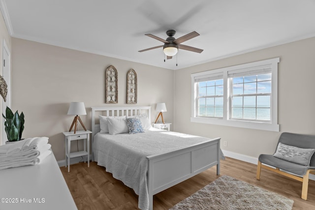 bedroom featuring hardwood / wood-style flooring, ornamental molding, and ceiling fan