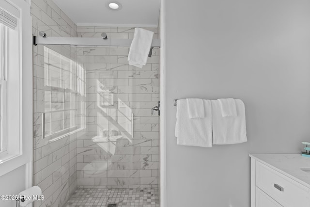 bathroom featuring a shower with door and vanity