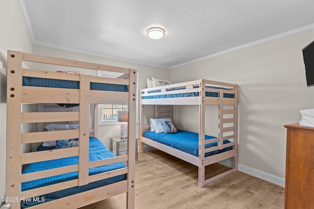 bedroom featuring ornamental molding and light wood-type flooring