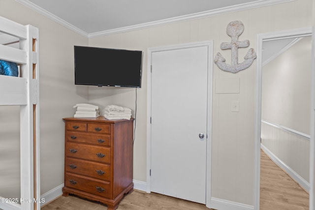 bedroom with ornamental molding and light hardwood / wood-style floors