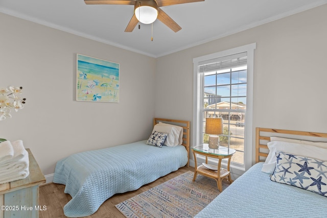 bedroom with hardwood / wood-style flooring, ceiling fan, and ornamental molding