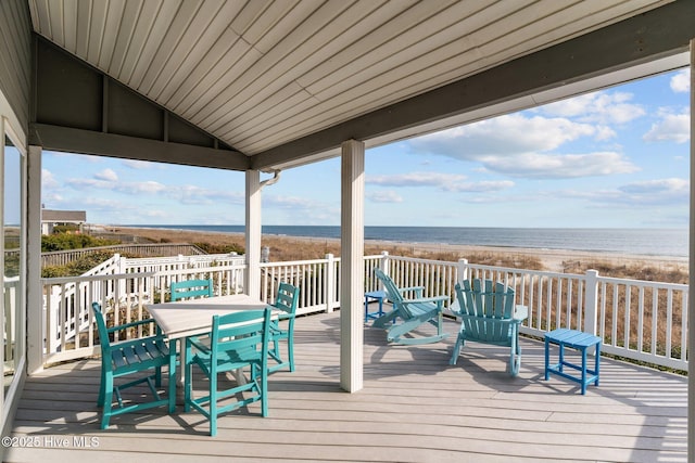 wooden terrace featuring a water view and a beach view