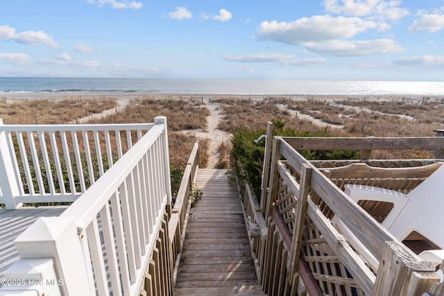 view of community with a water view and a beach view