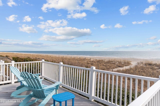 wooden deck featuring a water view and a view of the beach