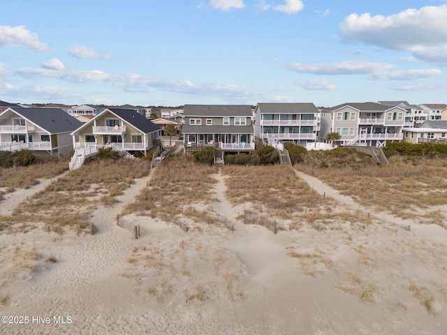 173 Ocean Blvd W # A, Holden Beach, NC 28462 - back of property with stairs, roof with shingles, a residential view, and a porch
