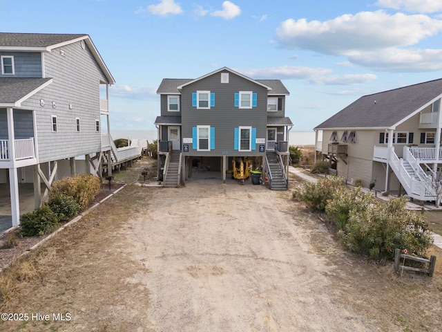 173 Ocean Blvd W # A, Holden Beach, NC 28462 - view of front of home featuring stairway, a shingled roof, and covered porch