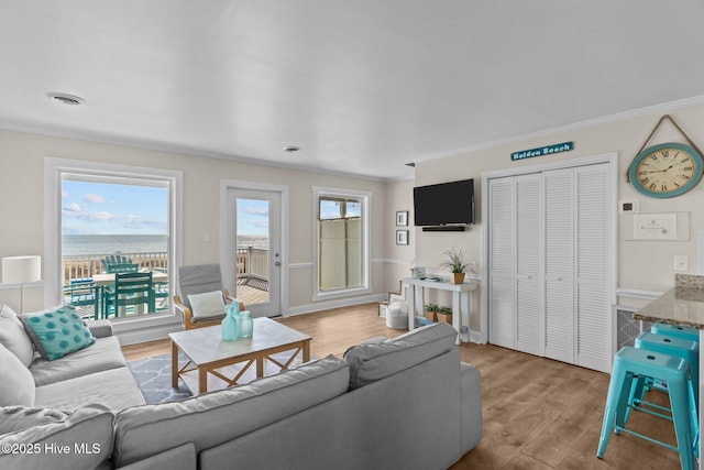 173 Ocean Blvd W # A, Holden Beach, NC 28462 - living area with crown molding, wood finished floors, baseboards, and a water view