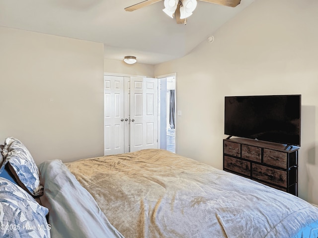 bedroom featuring lofted ceiling, ceiling fan, and a closet