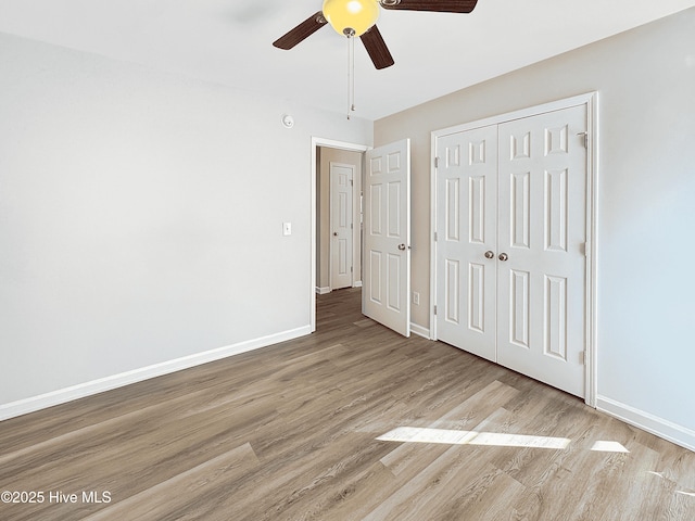 unfurnished bedroom featuring light hardwood / wood-style floors, ceiling fan, and a closet