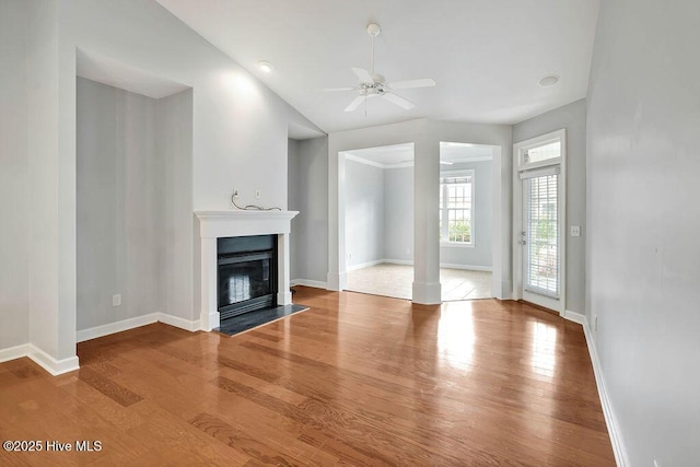 unfurnished living room with decorative columns, ceiling fan, lofted ceiling, and wood-type flooring