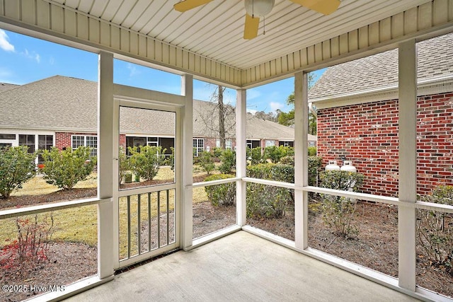 unfurnished sunroom with ceiling fan