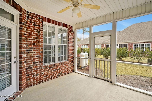 unfurnished sunroom featuring ceiling fan