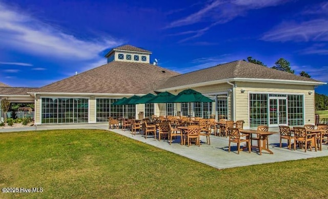 rear view of property featuring a lawn and a patio