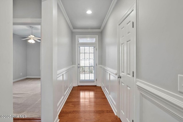 doorway to outside with crown molding, carpet floors, and ceiling fan