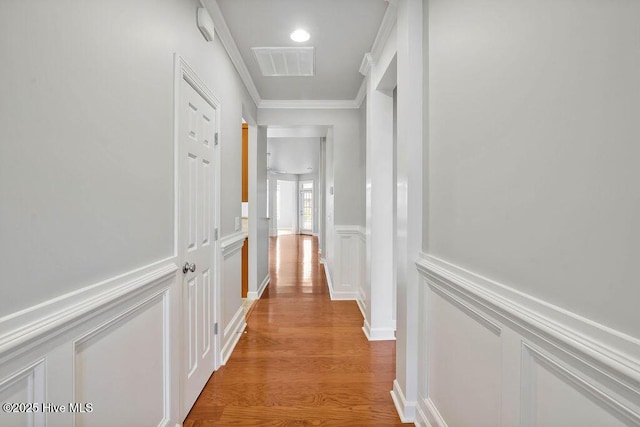 hall with light hardwood / wood-style flooring and ornamental molding