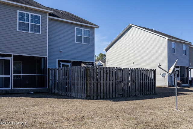 back of property featuring a sunroom and a yard