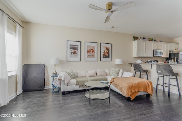 living room featuring ceiling fan and dark hardwood / wood-style flooring