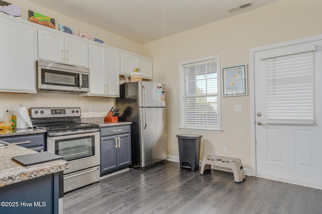 kitchen with dark wood-type flooring, gray cabinetry, stainless steel appliances, and white cabinets