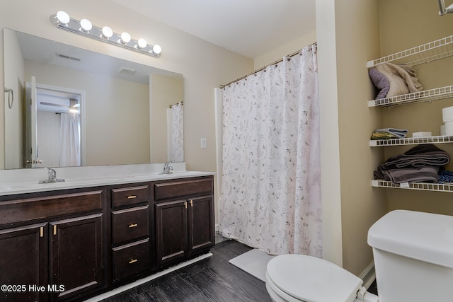 bathroom with vanity, wood-type flooring, and toilet