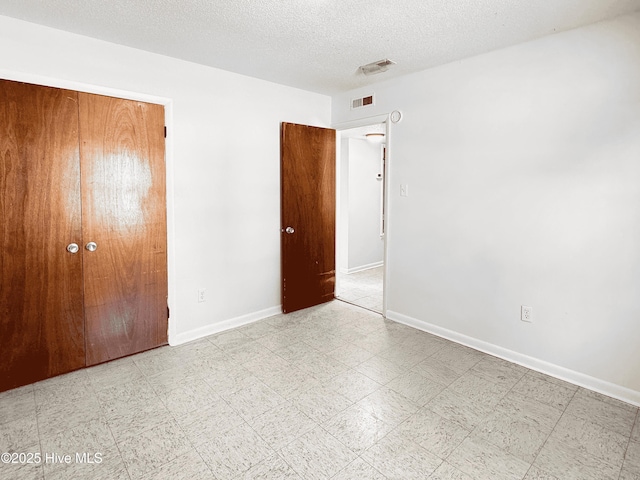 unfurnished bedroom featuring a closet and a textured ceiling