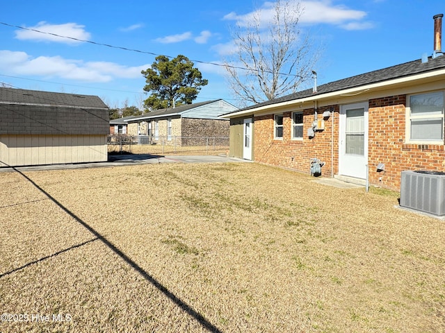 view of yard featuring central AC unit and a shed