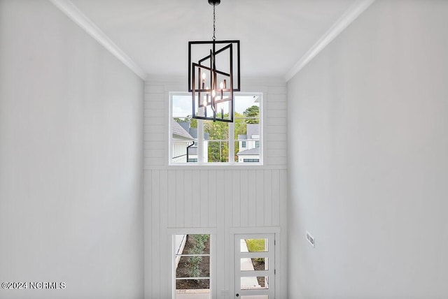 interior space featuring an inviting chandelier and crown molding