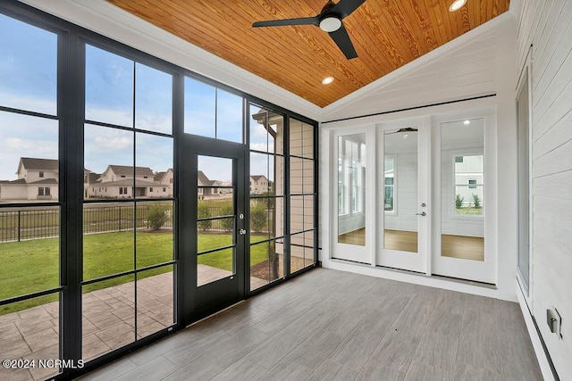 unfurnished sunroom with vaulted ceiling, a healthy amount of sunlight, and wood ceiling