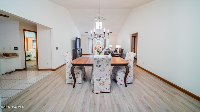 dining room with a notable chandelier, high vaulted ceiling, and light wood-type flooring