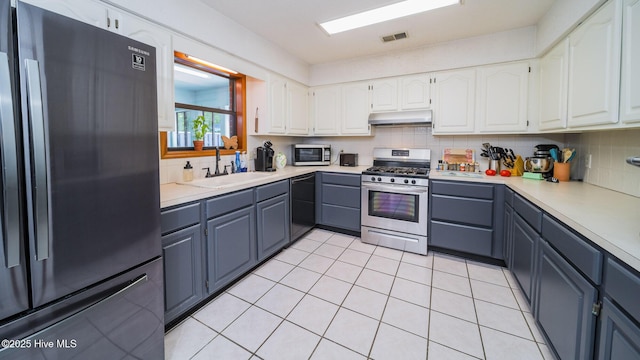 kitchen with tasteful backsplash, white cabinetry, sink, light tile patterned floors, and black appliances