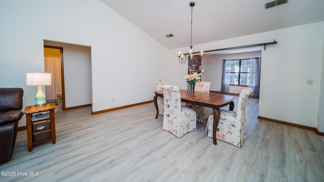 dining space featuring high vaulted ceiling, a chandelier, and light wood-type flooring