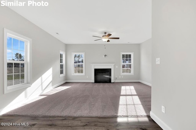 unfurnished living room featuring ceiling fan and hardwood / wood-style floors