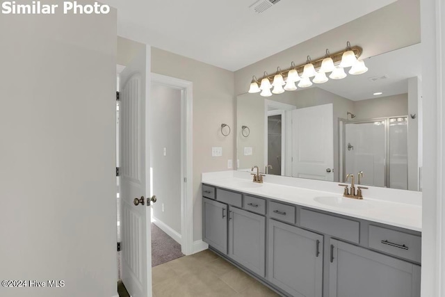 bathroom featuring vanity, tile patterned flooring, and a shower with door