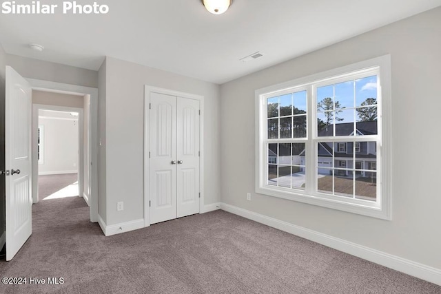 unfurnished bedroom featuring carpet and a closet